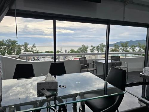 a dining room with a table and chairs on a balcony at PATONG TOWER SEA VIEW 3&4 BEDROOMS pta 2026 in Patong Beach