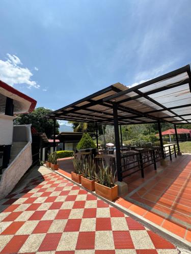 a pavilion with tables and potted plants on a patio at Villa Cristina San Javier in La Mesa