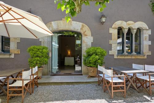 a restaurant with tables and chairs and a building at Hostal Sa Rascassa in Begur