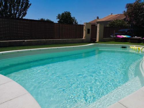 une piscine avec de l'eau bleue dans une cour arrière dans l'établissement Studio à 5 min de Narbonne, à Coursan