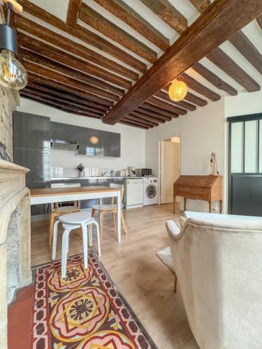 une cuisine et un salon avec une table et des chaises dans l'établissement Neptune, à Caen