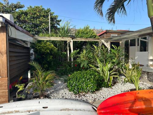 a garden with a surfboard in front of a house at Sunrise in Le Moule