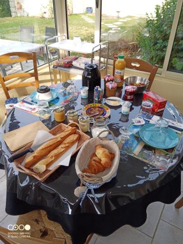 a table with bread and pastries on it at chambres et la table d'hôtes à la campagne in Senonches