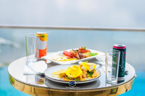 ein Tisch mit zwei Tellern Essen und einer Dose Limonade in der Unterkunft Nandoni Waterfront Resort in Thohoyandou