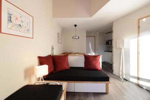 Cette chambre comprend un lit avec des oreillers rouges. dans l'établissement Résidence Callisto - 2 Pièces pour 5 Personnes 72, à Mâcot La Plagne