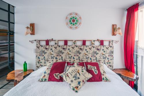 a bedroom with a bed with red pillows on it at AYCA La Flora Hotel Boutique in Valparaíso