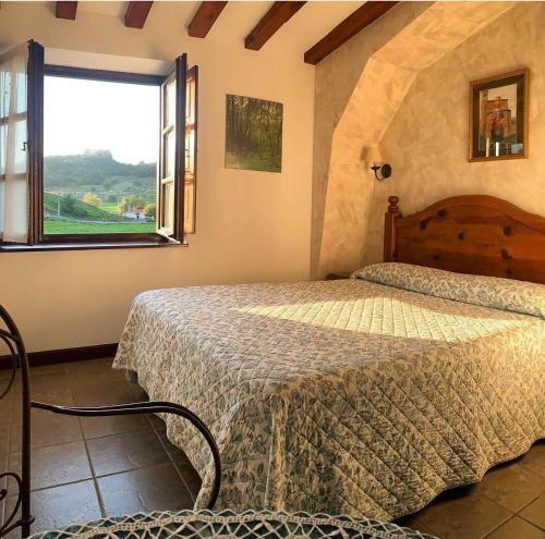 a bedroom with a bed and a window at Posada La Roblera in Oreña