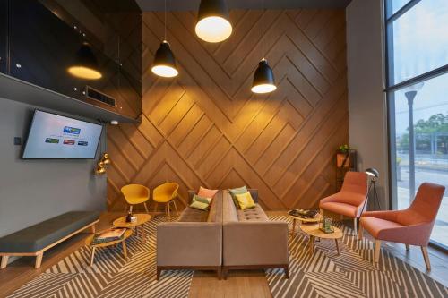 a living room with a couch and chairs at City Express Plus by Marriott Ciudad de México Periférico Sur Tlalpan in Mexico City