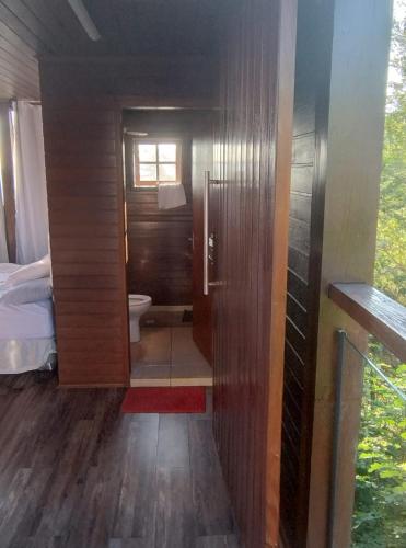 a bathroom with a toilet and a bed in a room at Pousada Chalezinho - Suite Crepúsculo in Santa Rita do Sapucaí