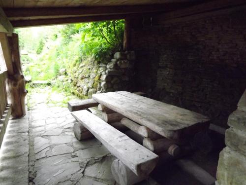 a wooden bench sitting on a stone patio at Chalupa pri potoku in Zuberec