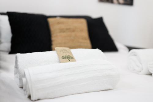 a pile of towels sitting on top of a bed at LUSSO e DESIGN, APPARTAMENTO 6 MINUTI AEROPORTO ORIO AL SERIO in Seriate