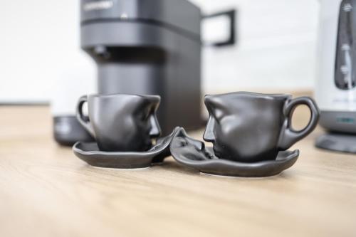 two coffee cups sitting on a counter top at LUSSO e DESIGN, APPARTAMENTO 6 MINUTI AEROPORTO ORIO AL SERIO in Seriate