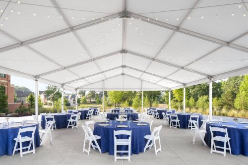 a marquee with blue tables and white chairs at Trilith Guesthouse, Fayetteville, GA, a Tribute Portfolio Hotel in Fayetteville
