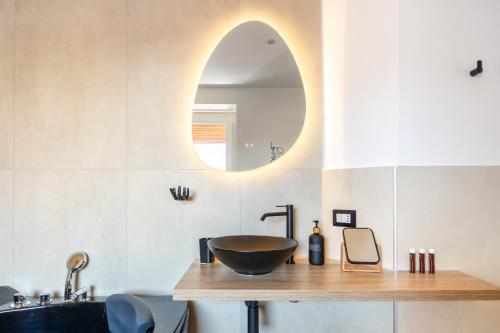 a bathroom with a bowl sink and a mirror at LUSSO e DESIGN, APPARTAMENTO 6 MINUTI AEROPORTO ORIO AL SERIO in Seriate