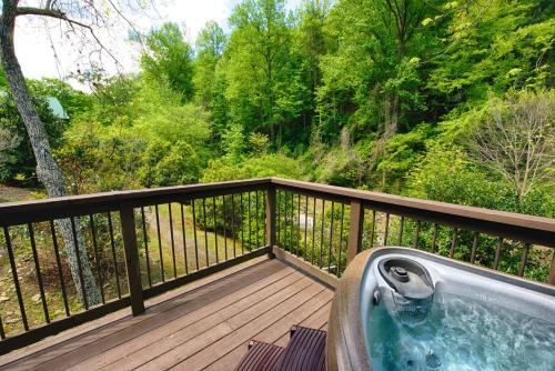 a hot tub on a wooden deck with trees at Historic Tapoco Lodge Resort in Tapoco