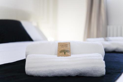 a pile of towels sitting on a bed at LUSSO e DESIGN, APPARTAMENTO 6 MINUTI AEROPORTO ORIO AL SERIO in Seriate