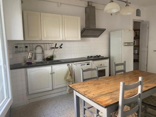 une cuisine avec une table en bois et un réfrigérateur blanc dans l'établissement Maison des Quais, à Arles