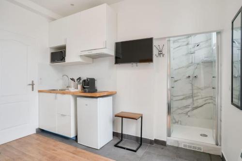 - une cuisine blanche avec un évier et une douche dans l'établissement Studio cosy et équipé à Créteil, à Créteil