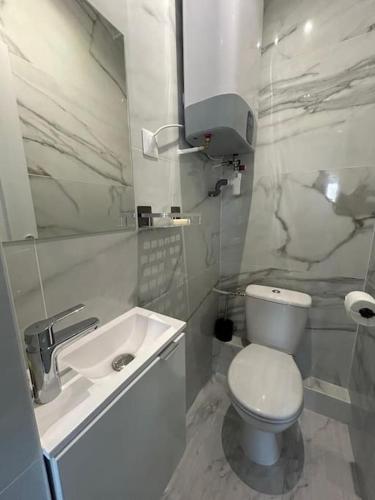 une salle de bain blanche avec des toilettes et un lavabo dans l'établissement Studio cosy et équipé à Créteil, à Créteil