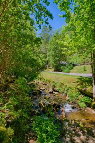 a creek in a park with trees and a road at Historic Tapoco Lodge Resort in Tapoco