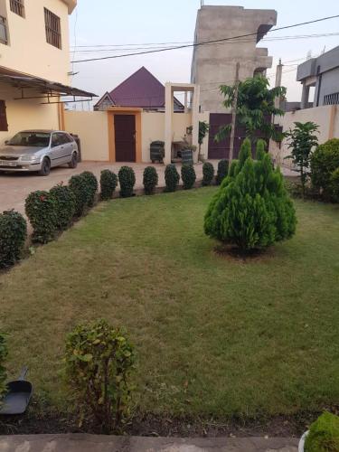 a yard with a car parked in front of a house at Odoux in Adékplovi