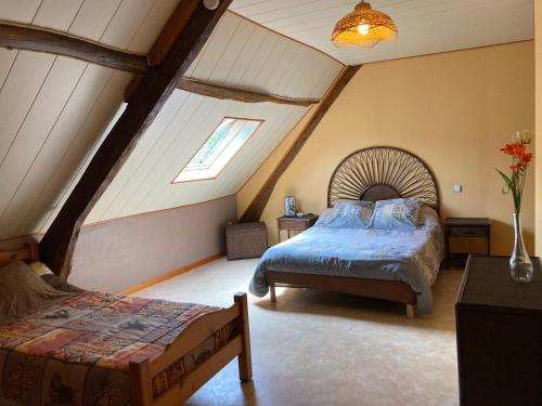 Un dormitorio con una cama en un ático en les trois monts, en Sère-Lanso