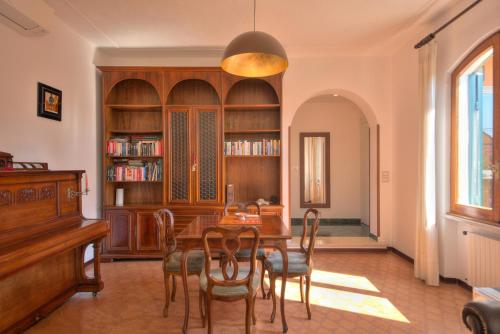a dining room with a table and chairs and a piano at Nel verde in Rapallo
