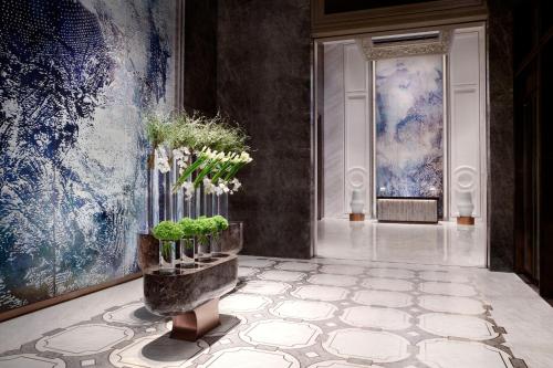 a lobby with a hallway with blue and white paintings at The Ritz-Carlton, Harbin in Harbin