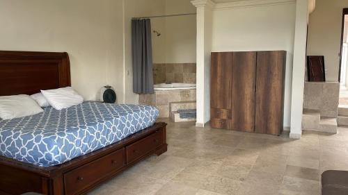 a bedroom with a bed and a bathroom with a tub at Jardin Zen in Tepoztlán
