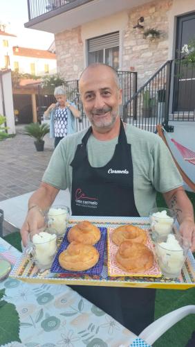 a man sitting at a table with a tray of food at casa carmelo in Schio