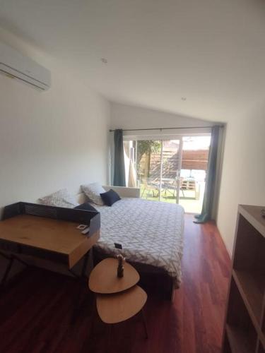 une chambre avec un lit et une table dedans dans l'établissement Studio à 5 min de Narbonne, à Coursan