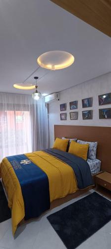 a bedroom with a bed with a blue and yellow blanket at La Maison Attawba in Beni Mellal