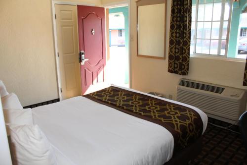a bedroom with a bed and a door with a window at Riverside Inn & Suites Santa Cruz in Santa Cruz
