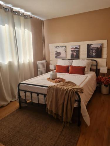 a bedroom with a bed with white sheets and red pillows at Le Parc in Sarcelles
