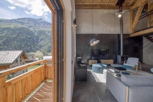 Cette chambre dispose d'un balcon avec une table et un canapé. dans l'établissement Chalet mitoyen - Jacuzzi - Cousinade I, aux Contamines-Montjoie