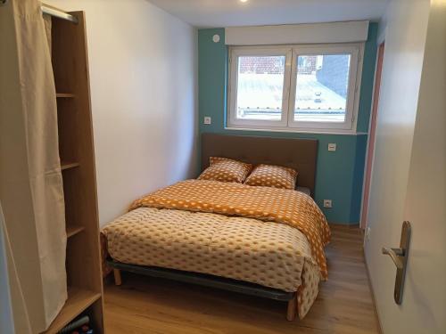 un lit dans une chambre avec une fenêtre dans l'établissement 50m de la plage - Appartement, à Mers-les-Bains