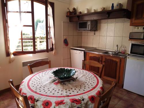 - une cuisine avec une table et des roses rouges dans l'établissement Appartement Rez de Jardin, à Luz-Saint-Sauveur
