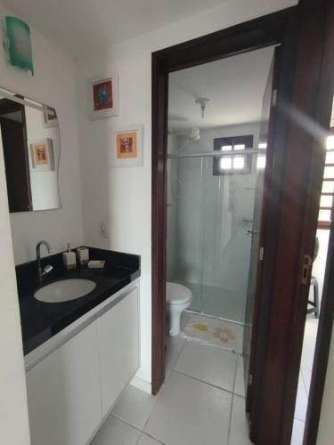 a bathroom with a shower and a sink and a toilet at Chalé Paisagem Serrana in Bananeiras