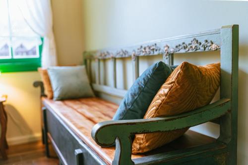 a wooden bench with pillows on it in a room at Chata w Leśnych Pieleszach - sauna & balia z jacuzzi na wyłączność in Łukawica