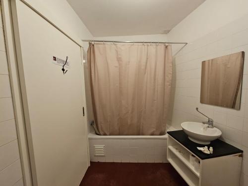 a white bathroom with a sink and a shower at Segredo do Castelo do Sabugal in Sabugal