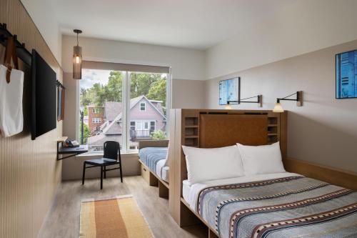 a bedroom with a bed and a window at Moxy Boulder University in Boulder