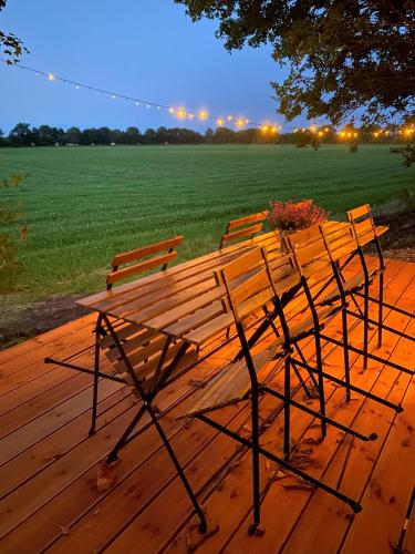 a wooden bench sitting on top of a wooden deck at Kroghs Tiny Houses - Hyttebyen in Grindsted