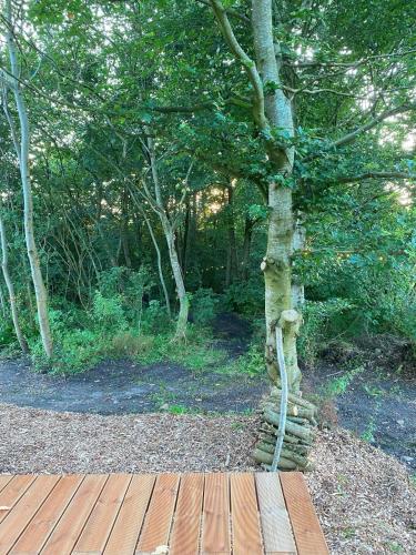 a tree with a rope tied to a wooden deck at Kroghs Tiny Houses - Hyttebyen in Grindsted
