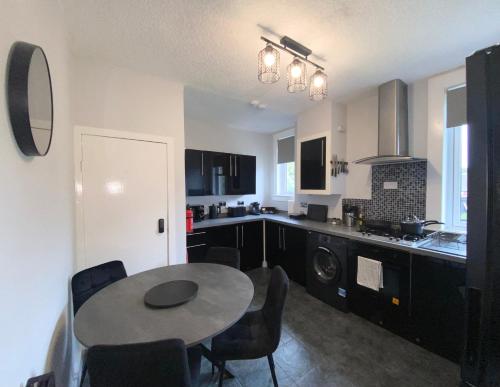a kitchen with a table and chairs in a room at Glasgow Apartment close to the airport in Renfrew