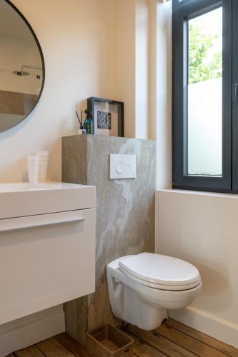 a bathroom with a white toilet and a mirror at Chill Hill in Hasselt