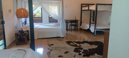 a bedroom with two bunk beds and a rug at Hotel oBeja negra Muki in Pitalito