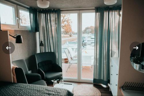 a living room with a view of a patio at Hausboot Urlaub in Ostfriesland auf der Waterhome 1 in Großefehn 