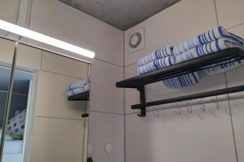 a bathroom with blue and white towels and a mirror at Hausboot Urlaub in Ostfriesland auf der Waterhome 1 in Großefehn 