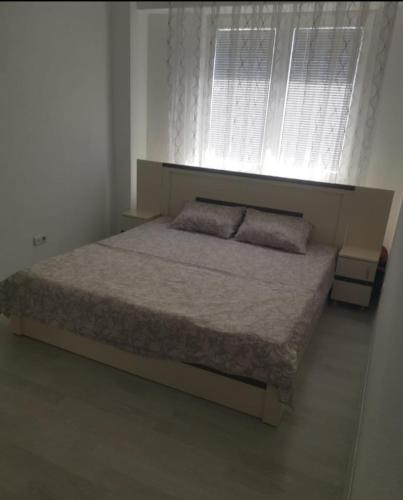 a bedroom with a large bed with a window at URBAN1 Ferizaj City in Ferizaj