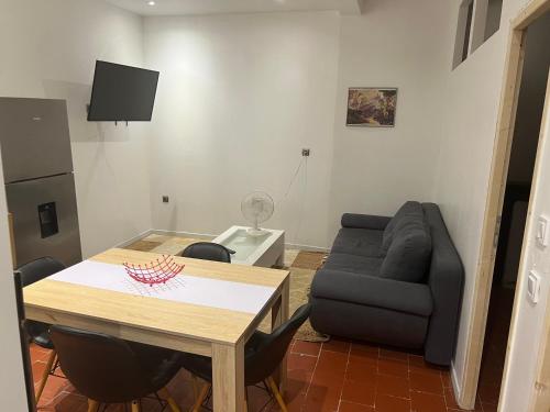 un salon avec une table et un canapé dans l'établissement Comme a la maison, à Béziers